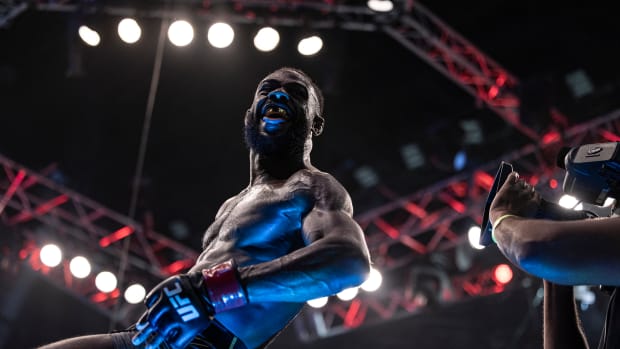 Aljamain Sterling (red gloves) celebrates after defeating T.J. Dillashaw (blue gloves) during UFC 280 at Etihad Arena.